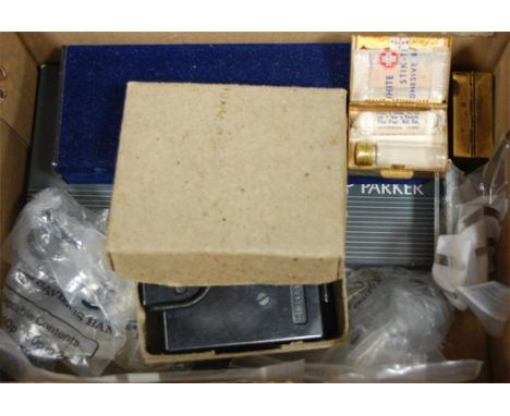 A box of commemorative and other crowns, Parker Pens, miniature First Aid kit, military compass etc