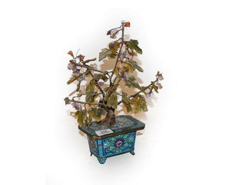 A Chinese cloisonne planter with hardstone tree.  33cm high, 25cm wide. Some pitting to the metal work and one or two chips t