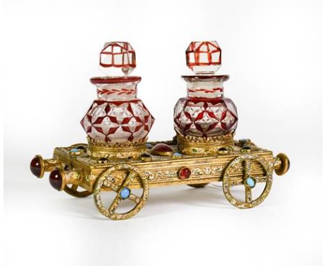 A Gilt-Metal, Gem-Set and Enameled Bottle-Stand, in the form of a flatbed rail carriage, set with various cabochon stones and