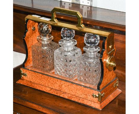 A birds eye maple and brass Betjemann's patent, three bottle tantalus .  Marked Betjemann, without key, decanter marriage, ge