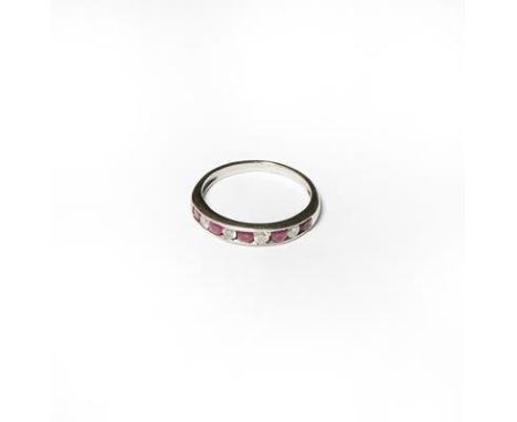 An 18 carat white gold ruby and diamond half hoop ring, finger size L1/2.  Gross weight 2.0 grams. 