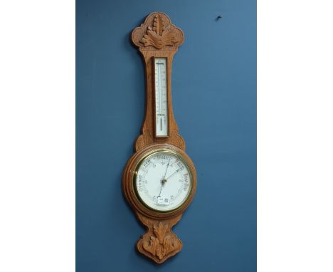 Early 20th century aneroid barometer with thermometer in carved light oak case, H83cm CLOCKS & BAROMETERS - as we are not a r