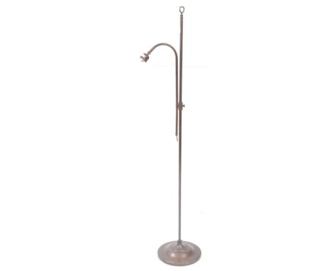 An early 20th century brass floor standing standard lamp. With adjustable stand, curved light with glass shade all raised on 