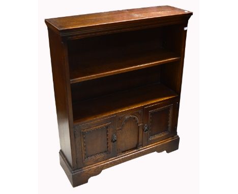 A 20th century oak bookcase with lower twin door cupboard section on bracket feet, width 84cm.