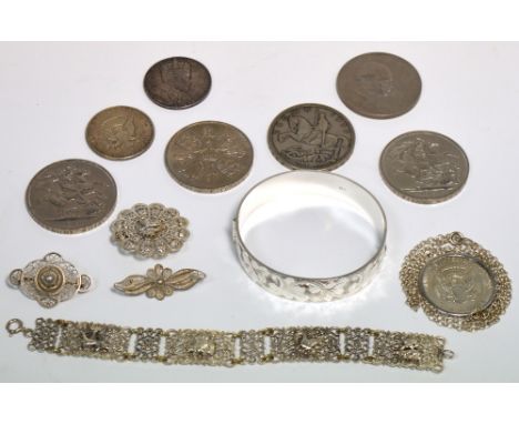 A hallmarked silver engraved bangle, a Dutch white metal bracelet, three white metal filigree brooches, an American Dollar on