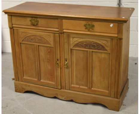 An early to mid 20th century Arts and Crafts style sideboard, two drawers over two lower cupboard doors with shelf to the int