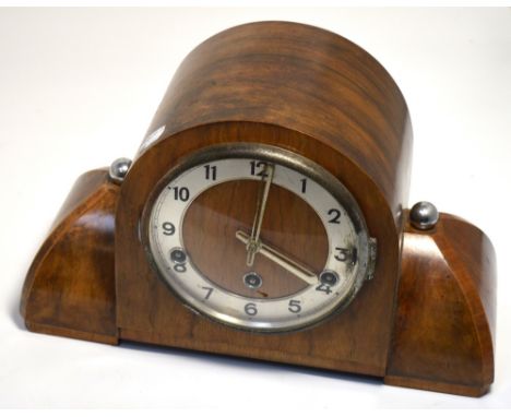 An Art Deco walnut mantel clock, silvered dial set with Arabic numerals.