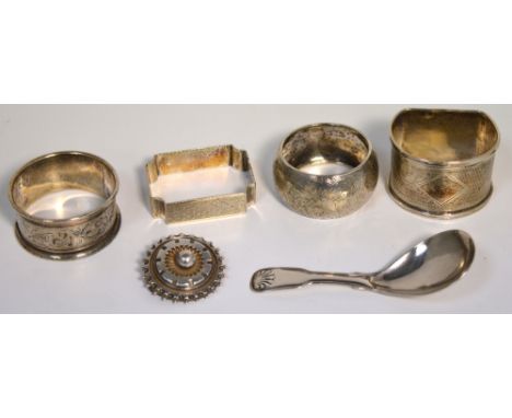 A Georgian hallmarked silver caddy spoon, marks rubbed, four hallmarked silver napkin rings, various hallmarks and a hallmark