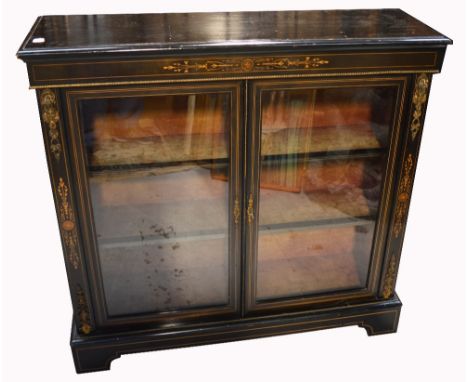 A late 19th early 20th century ebonised inlaid two door display cabinet, the top with foliate inlay above a brass rope trim o