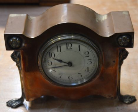 An early 20th century silver plated mantel clock, dial set with Arabic numerals on front supports with lion heads and paw fee