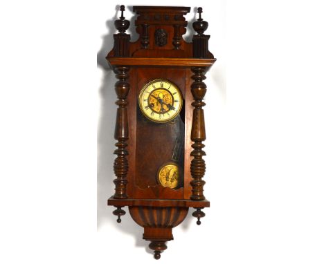 An early 20th century Viennese mahogany wall clock with gilded and enamel dial set with Roman numerals, length 85cm.