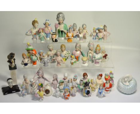 Approximately forty ceramic pin cushion heads, also a W.H Goss model of Egyptian water jar.