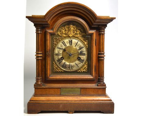 An early 20th century German fourteen day striking walnut cased mantel clock, the gilded and enamel dial set with Roman numer