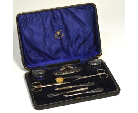 A cased manicure set comprising silver handle manicure items, two small trinket pots with hallmarked silver tops and a small 
