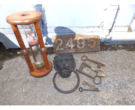 A brass lion mask door knocker, a wooden 'hour glass' timer, iron numerals '2495' and five old keys. (8)