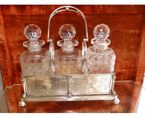 An EP swing-handled three-bottle decanter stand,  12" across.
