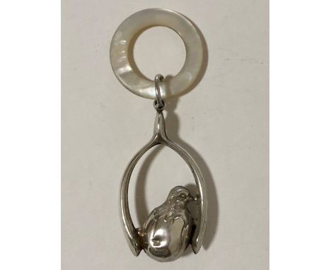 A silver &amp; mother-of-pearl baby's rattle in the form of a chick perched in a wishbone, Chester 1919.