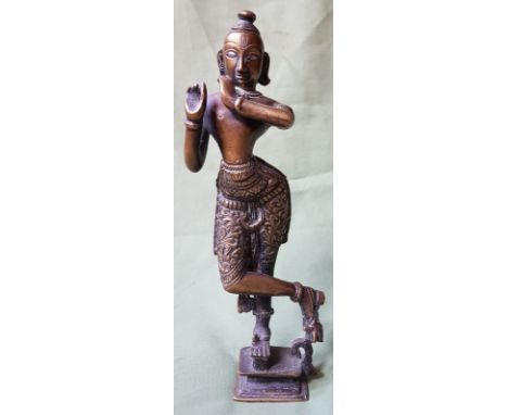 An antique Indian brass figure, the eyes and forehead inlaid with silver, 9" high.