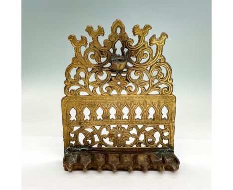 Thick bronze Judaica oil lamp with bird, scroll and flower motif, eight slots. Dimensions: 6.5"L x 2"W x 8"HCondition: Age re