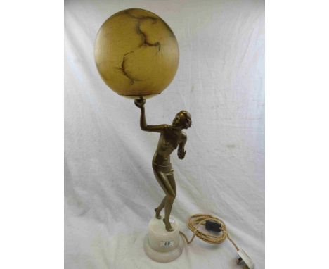 Art Deco figural spelter table lamp depicting a standing semi-nude woman twisting to look at the globe in her hand, marbled y