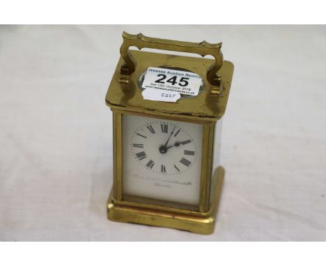 Brass carriage clock, white enamel dial with black Roman numerals and black poker hands, makers name to face indistinct, face