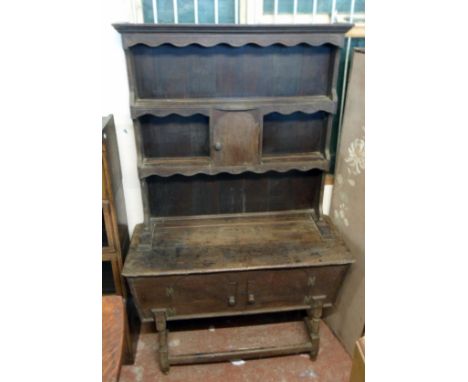 A 3' 9" antique oak two part dresser, formed from an older dough bin, set on turned supports and open stretcher base, surmoun