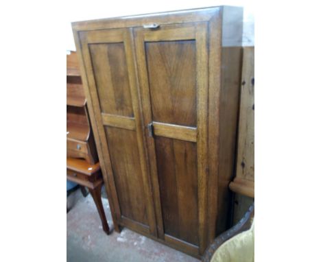 A 36" vintage polished oak gentleman's wardrobe with shelf fitted and hanging space interior enclosed by a pair of panel door