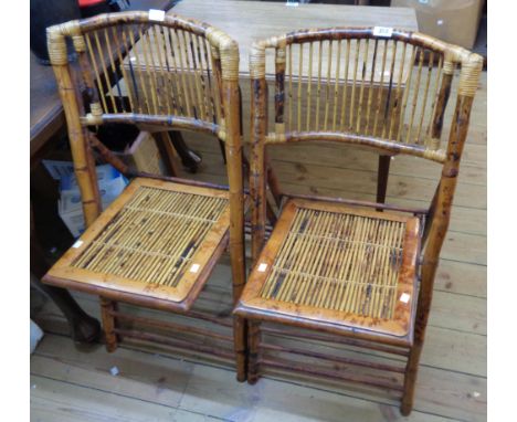 A pair of modern bamboo and cane framed folding chairs with stick set backs and seat panels