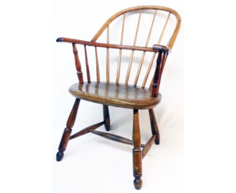 An antique elm bow-back Windsor style country elbow chair with thick solid oval seat panel, set on turned front supports - la