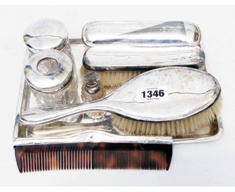 A silver harlequin eight piece dressing table set comprising three brushes, jar, hair tidy, scent bottle, comb and oblong tra