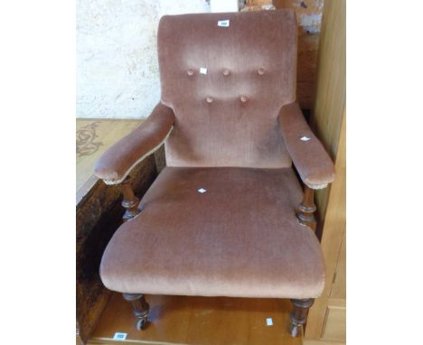A late 19th Century walnut framed open armchair upholstered in button back old rose velour, set on turned front legs and brow