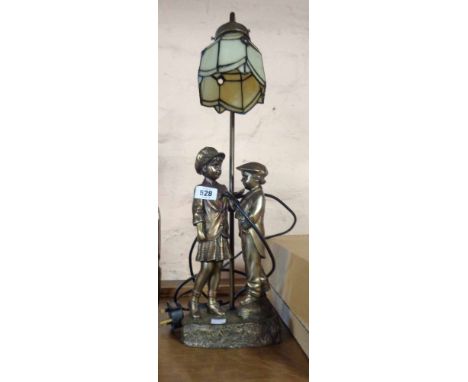 A figural table lamp with opaque shade