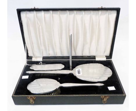 A cased Broadway silver mounted four piece dressing table brush and hand mirror set with engraved and engine turned decoratio