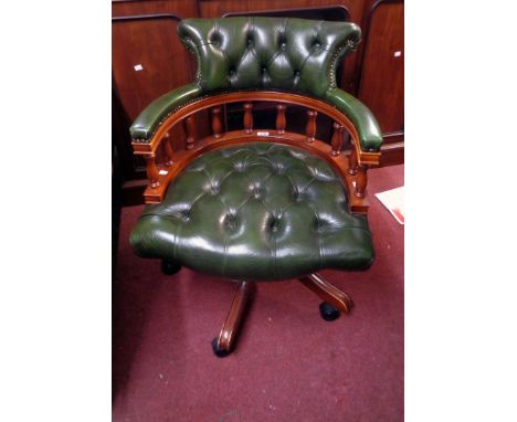 A late 20th Century polished wood framed captain's style swivel office chair upholstered in green button back leather, set on