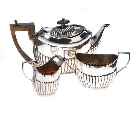 THREE PIECE EMBOSSED SILVER BREAKFAST TEA SERVICE, TEA POT WITH AN OVAL HINGED LID AND A CARVED FRUIT WOOD HANDLE LONDON 1896