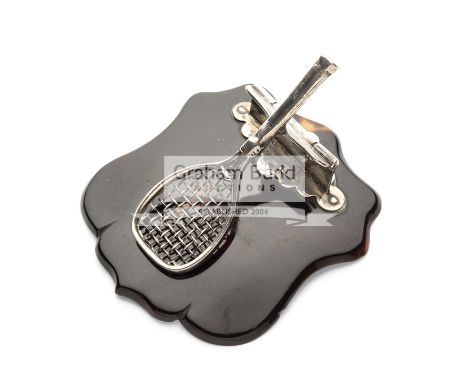 A very unusual silver Tennis Racquet paper clip on a tortoiseshell base, the racquet on a hinged back attached to the tortois