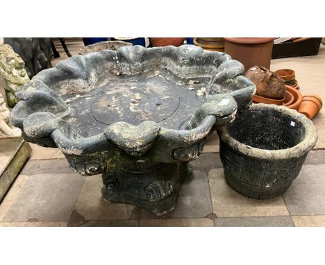 A concrete bird bath and a planter 