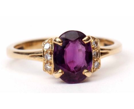 Modern 18K stamped amethyst and diamond ring, the oval shaped faceted amethyst claw set and raised between diamond chipped sh