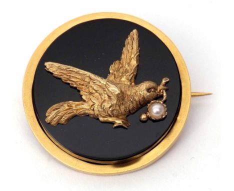 Vintage yellow metal onyx and seed pearl brooch, the circular onyx panel applied with a bird in flight carrying an olive bran