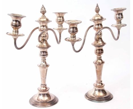 Two late 20th century electro-plated three light candelabra, each with detachable nozzles and urn shaped sconces on scrolling