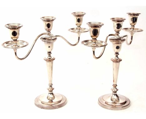 Pair of early 20th century silver on copper three-light candelabra, each with detachable drip pans and urn shaped sconces on 