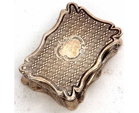 Early Victorian vinaigrette of shaped rectangular form, the hinged cover with engine turned decoration and central vacant car