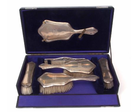 Cased Edward VII five-piece dressing table set comprising hand mirror, pair of hair brushes, pair of clothes brushes and silv