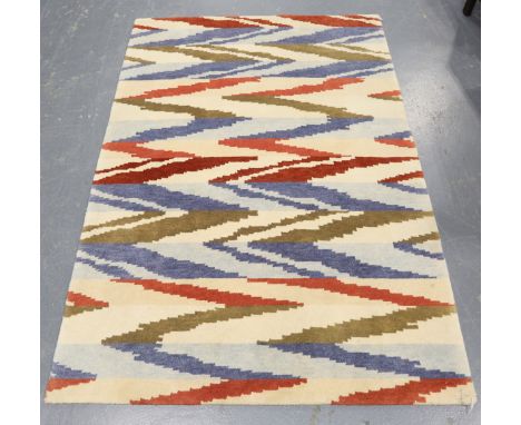 A contemporary design rug, modern, the ivory field with geometric polychrome bands, 180cm x 125cm.Buyer’s Premium 29.4% (incl