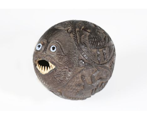 A 19th century Mexican coconut 'bugbear' money box with finely carved relief decoration, one end typically modelled with a fa