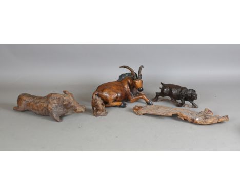 A 20th century Eastern carved wooden model of a recumbent antelope, length 48cm, two similar models of warthogs and a model o