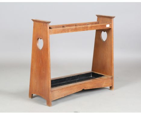 An Edwardian Arts and Crafts oak five-division stick stand, in the manner of Liberty &amp; Co, each end with a pierced heart 