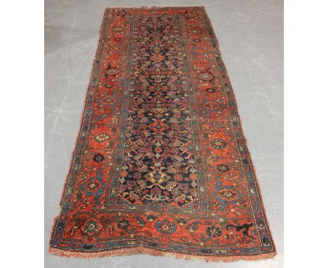 A Feraghan runner, North-west Persia, early 20th century, the midnight blue field with overall herati, within a terracotta tu