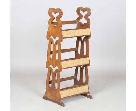 An Edwardian Arts and Crafts oak three-tier book trough, in the manner of Liberty &amp; Co, the pierced ends uniting three sh