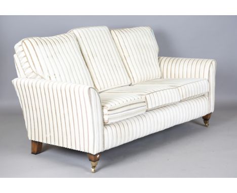 A late 20th century three-seat settee, upholstered in striped fabric, on square tapering legs and brass castors, height 80cm,